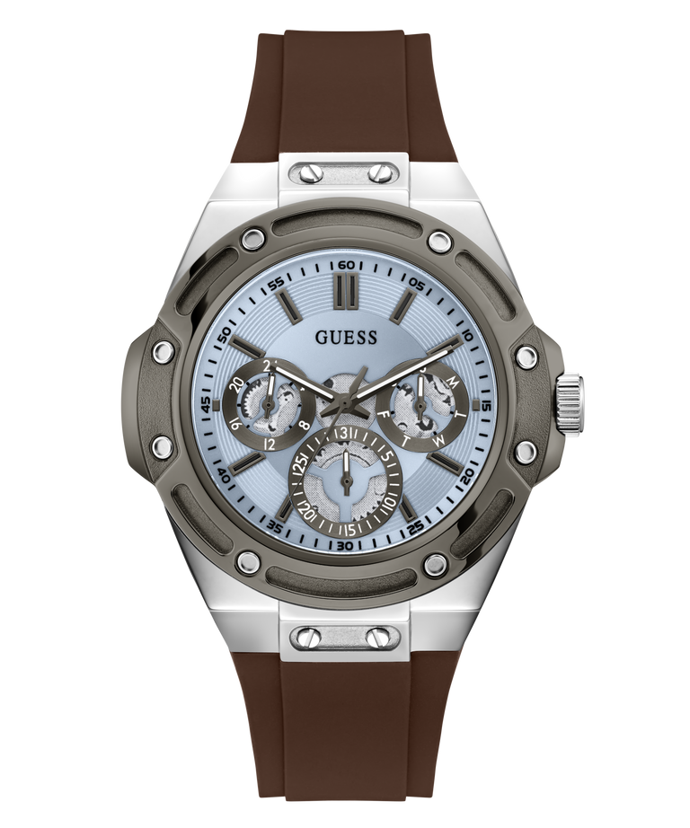 A Guess men's watch featuring a silver stainless steel case, a light blue dial with three sub-dials, and a brown silicone strap, shown against a plain white background.