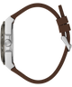 A close-up side profile of a smartwatch with a brown silicone strap and a silver-toned metal case on a plain white background.