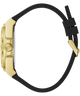 A side profile view of a gold-tone watch with a black silicone strap on a solid white background.