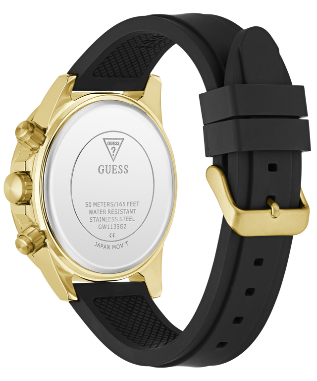 A GUESS watch shown from the back, featuring a gold-tone case, a white backplate with brand text, and a black silicone strap with a gold buckle.