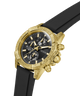A Guess men's chronograph watch featuring a textured gold-tone case, a black dial with gold-tone subdials and markers, and a black rubber strap, shown on a white background. lifestyle