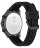 The back view of a Guess watch with a black silicone strap and a dark gray metallic case, showing the branded water-resistant case back.
