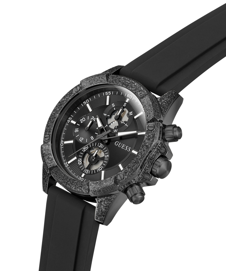 A Guess chronograph watch with a textured dark gray and black case, a black dial with white markings, and a black rubber strap, shown on a plain white background. lifestyle