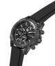 A Guess chronograph watch with a textured dark gray and black case, a black dial with white markings, and a black rubber strap, shown on a plain white background. lifestyle
