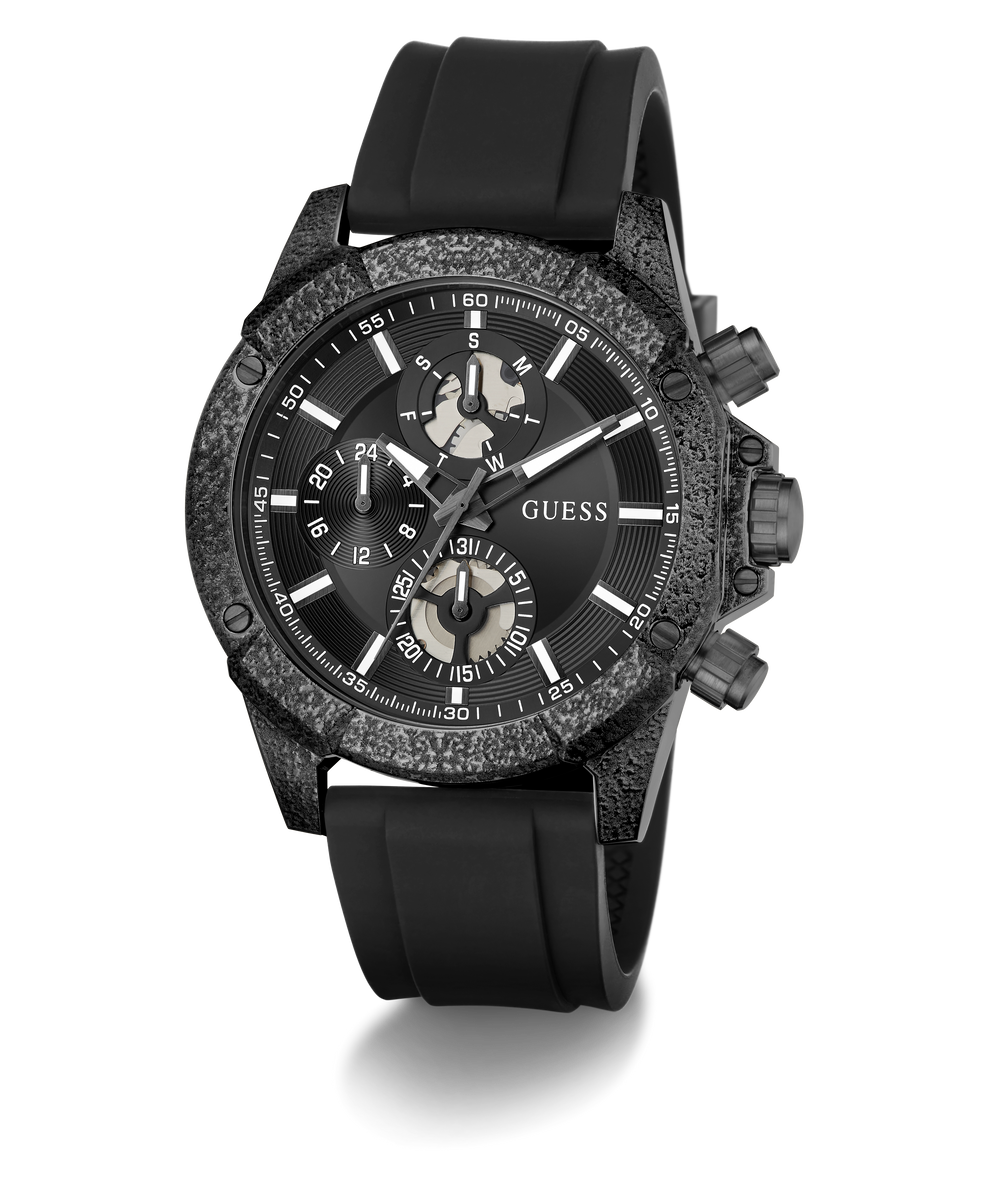 A GUESS chronograph watch with a textured dark gray and black case, a black dial with white markings, and a black rubber strap, shown on a white background with a soft shadow.