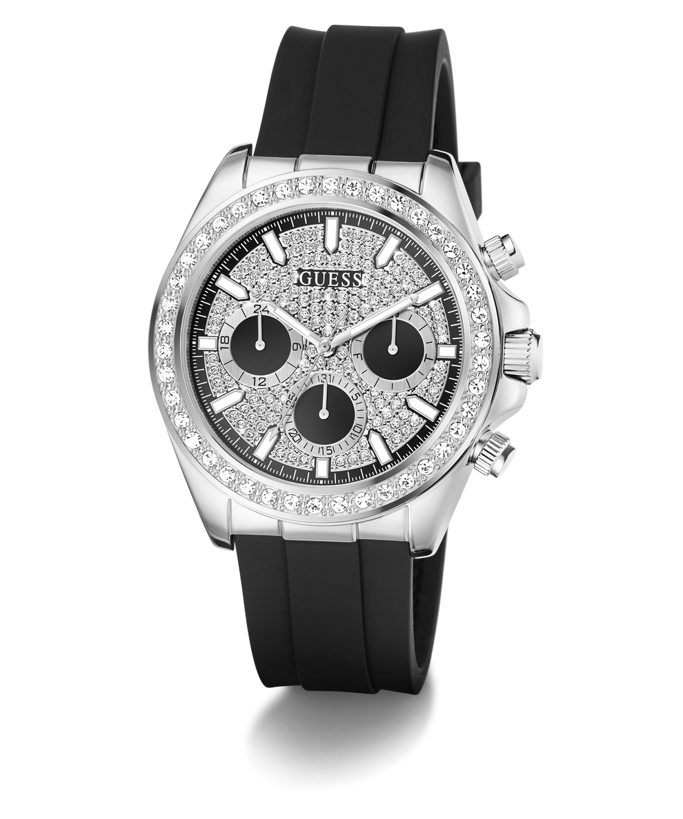 A Guess wristwatch with a silver-tone case, a bezel set with clear stones, a textured black dial with three black subdials, and a black silicone strap, shown on a white background.