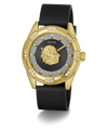 A luxury wristwatch by GUESS featuring a gold-tone case with a lion head dial, a black leather strap, and a bezel accented with diamonds.