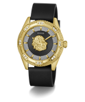 A luxury wristwatch by GUESS featuring a gold-tone case with a lion head dial, a black leather strap, and a bezel accented with diamonds.
