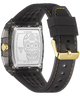 Back view of a GUESS watch with a transparent case, silver engraved back plate featuring a sugar skull design, and a black silicone strap with yellow stitching and a gold buckle.