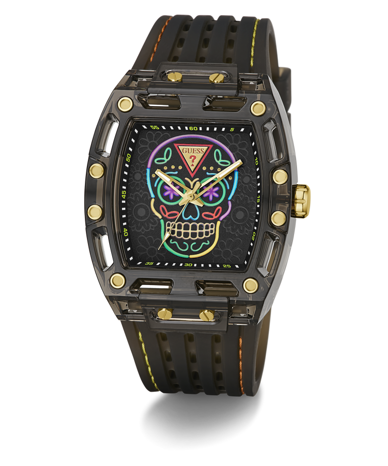 A luxury wristwatch with a black carbon fiber case, a black textured strap with yellow stitching, and a colorful Day of the Dead sugar skull dial. The watch features gold-tone screws and hands, and is photographed on a clean white background with a soft shadow.