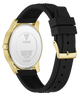 The back of a GUESS watch with a gold-tone case and a black textured silicone strap, shown on a clean white background.
