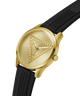 A gold-tone Guess wristwatch with a textured black silicone strap, shown at an angle on a solid white background. lifestyle