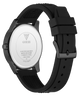 The back view of a GUESS watch with a black silicone strap and a dark gunmetal case, showing the silver-toned stainless steel case back with the GUESS logo.