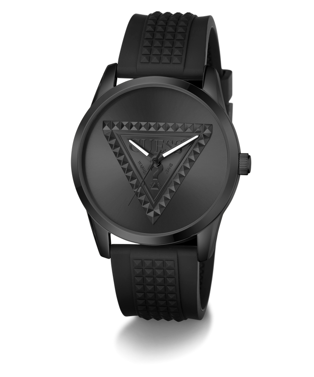 A black Guess wristwatch with a textured triangular logo on the dial and a matching black silicone strap with a pyramid pattern, shown against a plain white background.