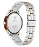 Rear view of a GUESS stainless steel watch with a two-tone silver and gold-tone metal link bracelet and a translucent brown tortoiseshell case back.