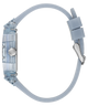 A side profile view of a GUESS watch with a translucent light blue case and a matching light blue silicone strap, featuring a silver-tone buckle and crown.