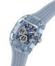 A GUESS wristwatch with a transparent light blue case and matching silicone strap, featuring a blue skeleton dial with silver-tone subdials and markers. lifestyle