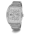 A luxury Guess wristwatch with a silver-tone metal case and bracelet, heavily embellished with sparkling clear crystals. The dial is a complex multi-dial skeleton design with matching crystal details, featuring the GUESS brand name at the top.