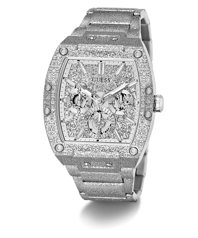 A luxury Guess wristwatch with a silver-tone metal case and bracelet, heavily embellished with sparkling clear crystals. The dial is a complex multi-dial skeleton design with matching crystal details, featuring the GUESS brand name at the top.