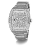 A luxury Guess wristwatch with a silver-tone metal case and bracelet, heavily embellished with sparkling clear crystals. The dial is a complex multi-dial skeleton design with matching crystal details, featuring the GUESS brand name at the top.