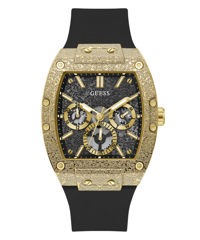 A luxury wristwatch by Guess featuring an ornate gold-tone case with a textured bezel, a black multi-dial dial, and a black rubber strap, shown against a plain white background.