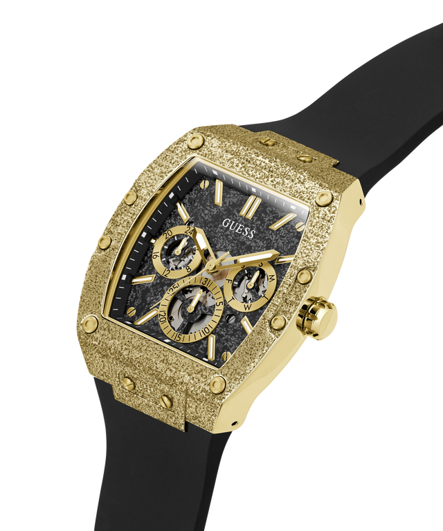 A Guess men's watch featuring a textured gold-tone case, a black dial with gold subdials and markers, and a black rubber strap, shown on a solid white background. lifestyle