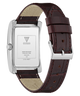 A GUESS wristwatch shown from the back, featuring a silver stainless steel case and a dark brown leather strap with a silver buckle, on a white background.