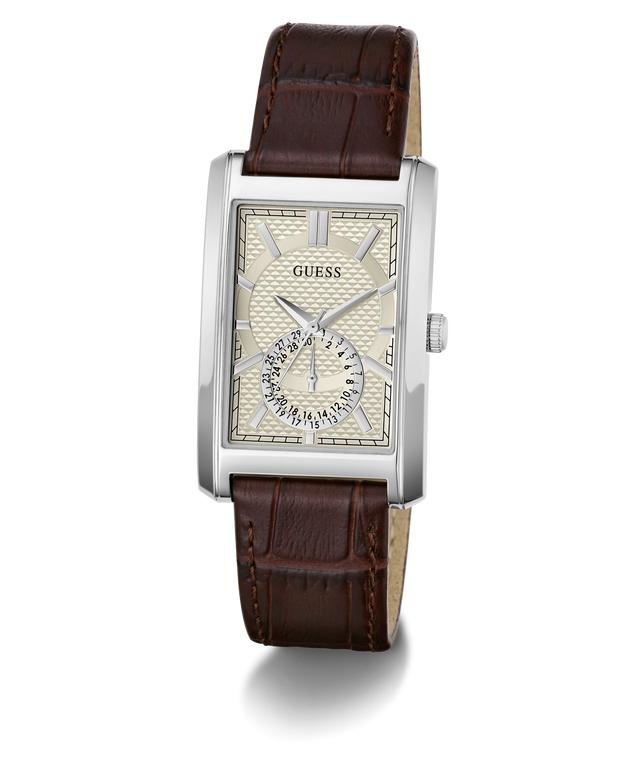 A GUESS men's analog watch featuring a silver-tone rectangular case, a cream-colored dial with a small sub-dial, and a dark brown leather strap with a crocodile-embossed texture.