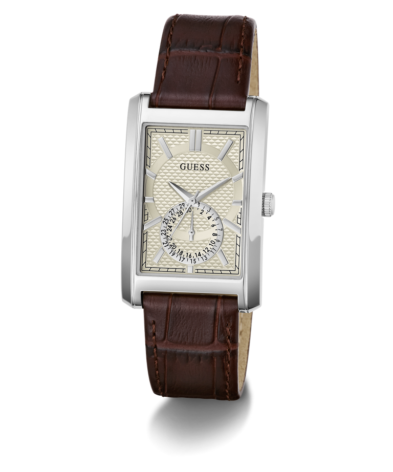 A GUESS men's analog watch featuring a silver-tone rectangular case, a cream-colored dial with a small sub-dial, and a dark brown leather strap with a crocodile-embossed texture.
