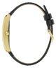 Close-up side view of a watch with a slim black leather strap and a polished gold-tone case and buckle, shown on a plain white background.