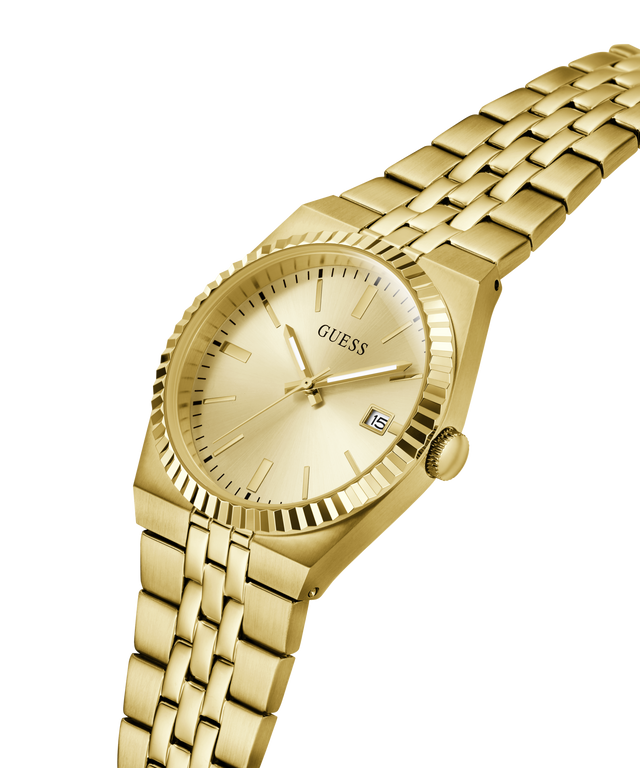 Gold-tone stainless steel wrist watch with a matching link bracelet, featuring a fluted bezel, gold dial with slim hour markers, and a date window at 3 o'clock. The GUESS brand name is visible on the dial. lifestyle