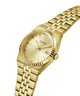 Gold-tone stainless steel wrist watch with a matching link bracelet, featuring a fluted bezel, gold dial with slim hour markers, and a date window at 3 o'clock. The GUESS brand name is visible on the dial. lifestyle
