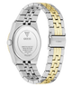 A close-up rear view of a GUESS wristwatch with a two-tone stainless steel and gold link band, showing the branded metal case back and clasp on a white background.