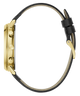 A side profile view of a gold-tone watch with a black leather strap on a solid white background.