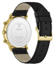 The back view of a GUESS wristwatch with a gold-tone case, black leather strap, and white back cover showing the brand logo and specifications.