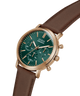 A Guess chronograph watch with a green dial and rose gold case, paired with a brown leather strap, shown on a clean white background. lifestyle