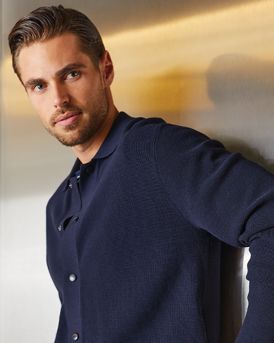 Man wearing a navy blue sweater against a neutral background