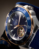 Close-up of a Guess Automatic wristwatch with a blue dial, blue bezel, blue strap, and silver-toned case with gold-tone accents.