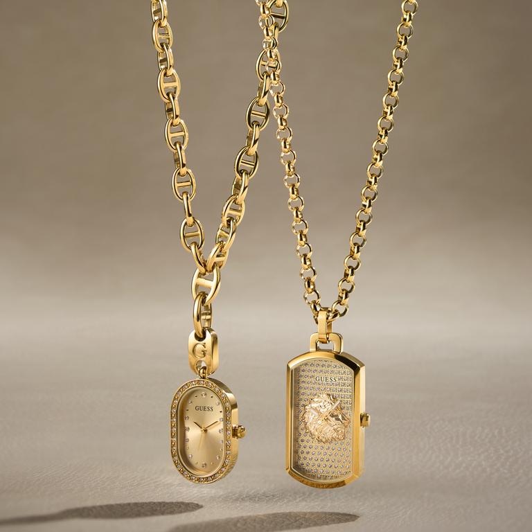 Two gold necklaces displayed against a warm beige background. One necklace features an oval pendant with a gold dial and a diamond-studded bezel, while the other features a rectangular locket pendant with a lion head motif and textured center.