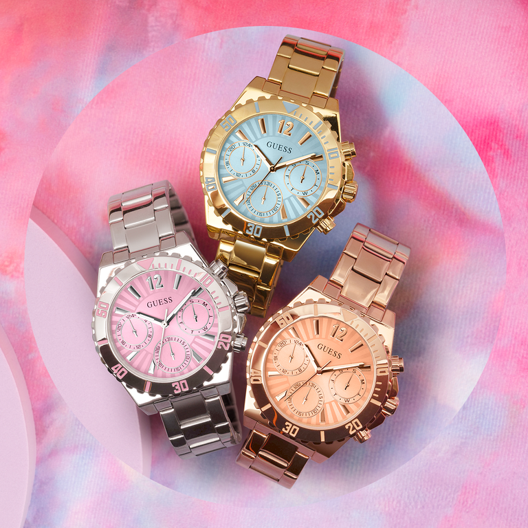 three colored womens watches on pink background
