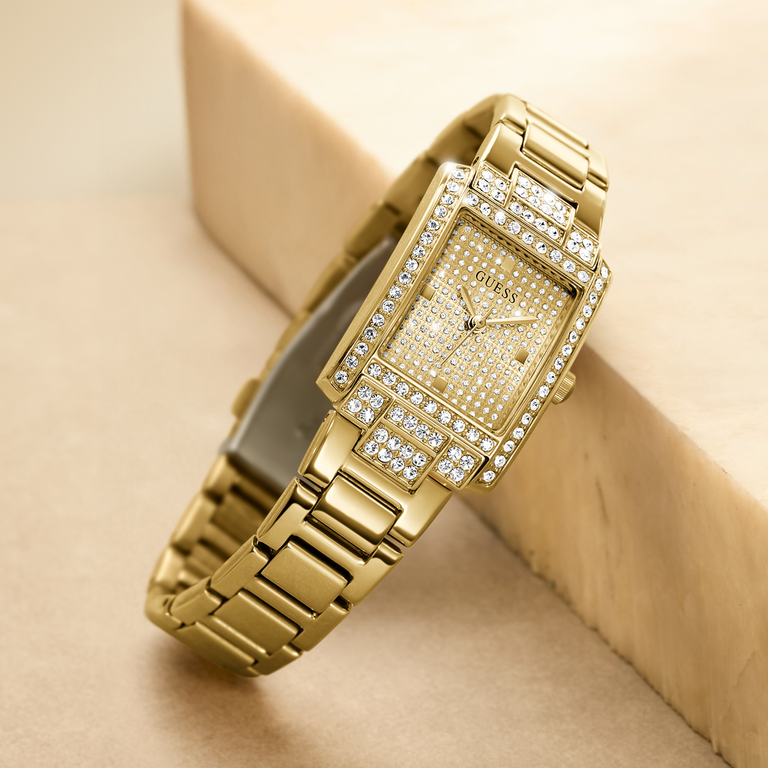Gold watch with diamond accents on a beige background