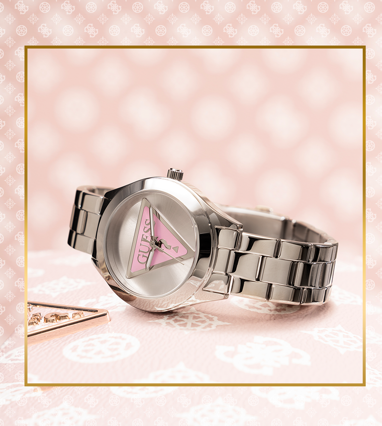 silver watch with pink logo on dial on G pattern background