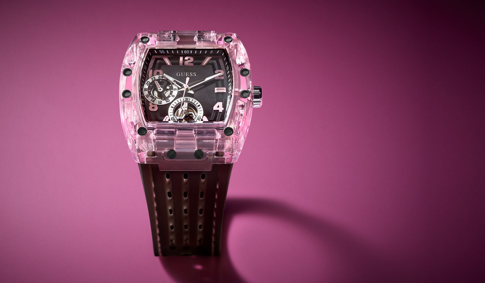 Sporting Pink Watch with transparent pink case and black strap on a purple background