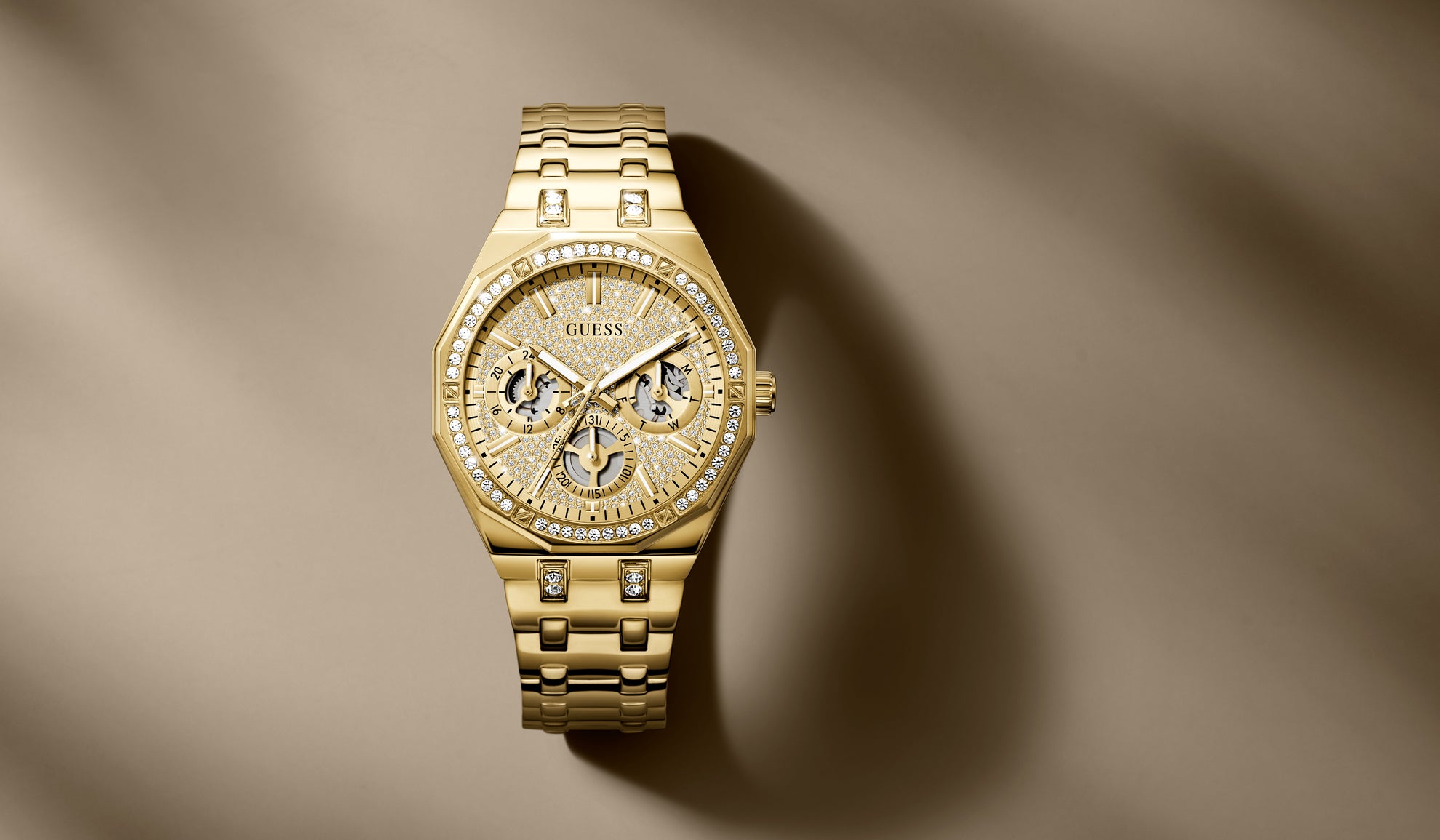 Gold watch with diamond accents on a brown fabric background