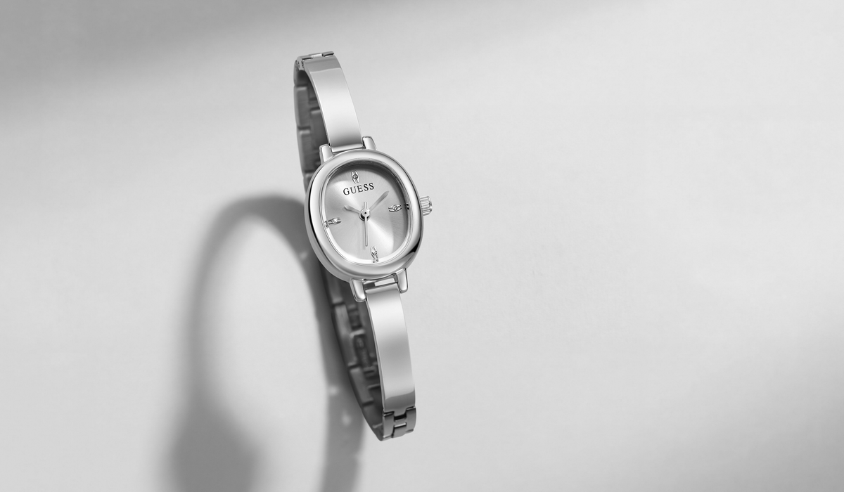 A silver-tone wristwatch with a round bezel and matching metal link bracelet, shown on a light gray background with a soft shadow.