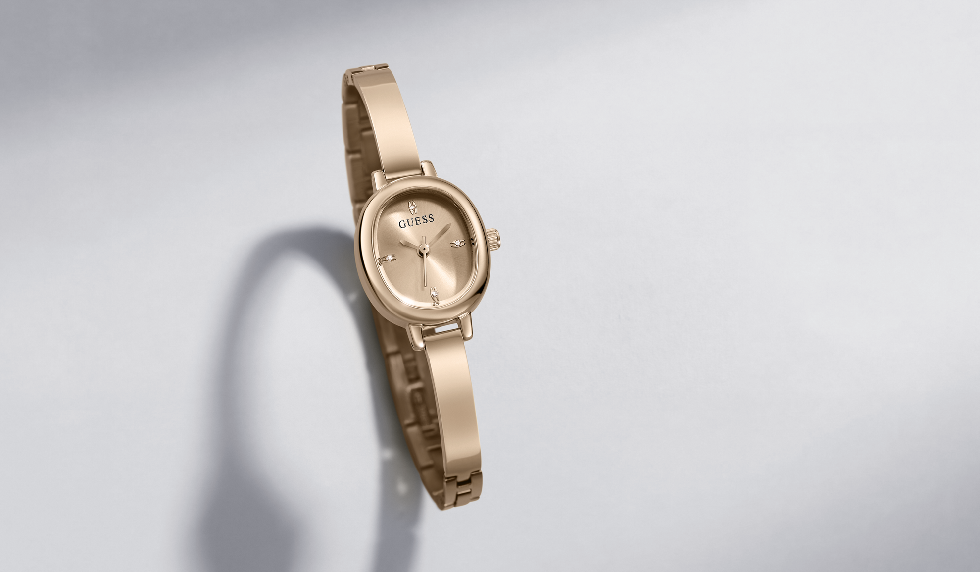 A gold-tone women's analog watch with a matching metal bracelet, shown at an angle on a light gray background with a soft shadow.