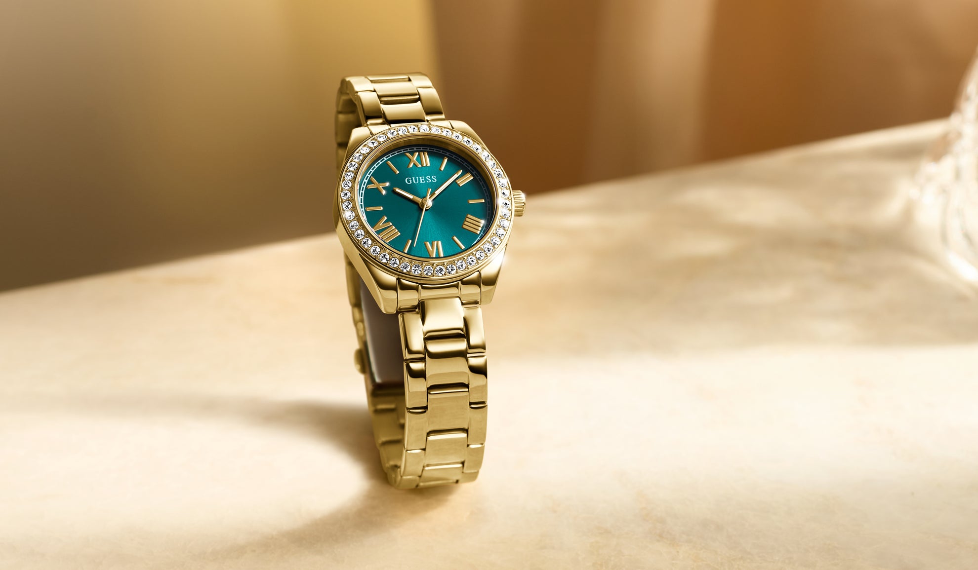 womens gold watch with a green dial and crystals on the bezel