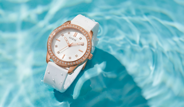 White watch with rose gold accents on a blue water background