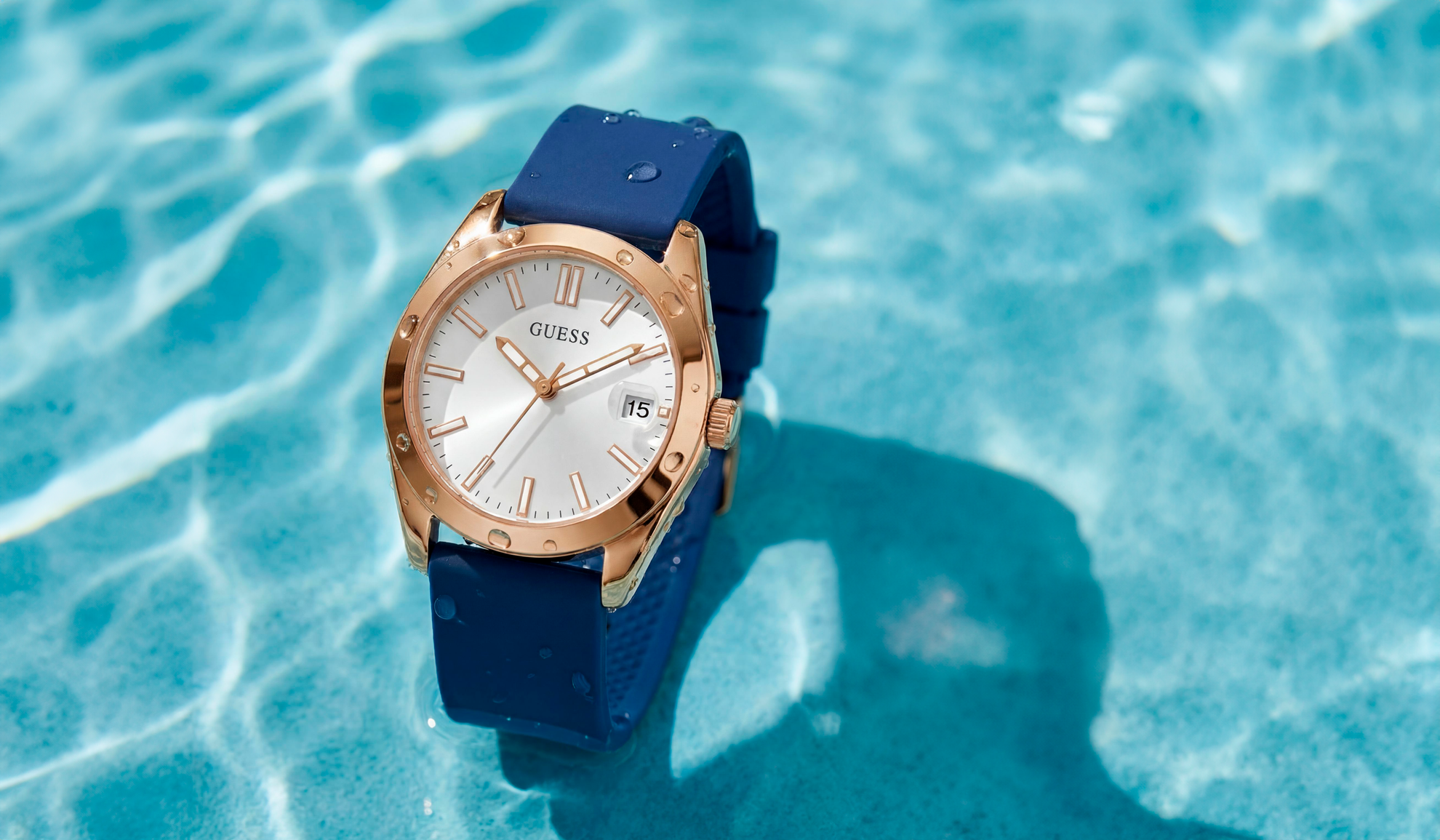 Guess watch with blue strap on a reflective water surface