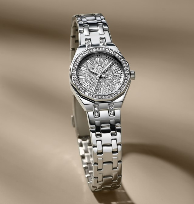 Silver watch with diamond-studded face on a beige background